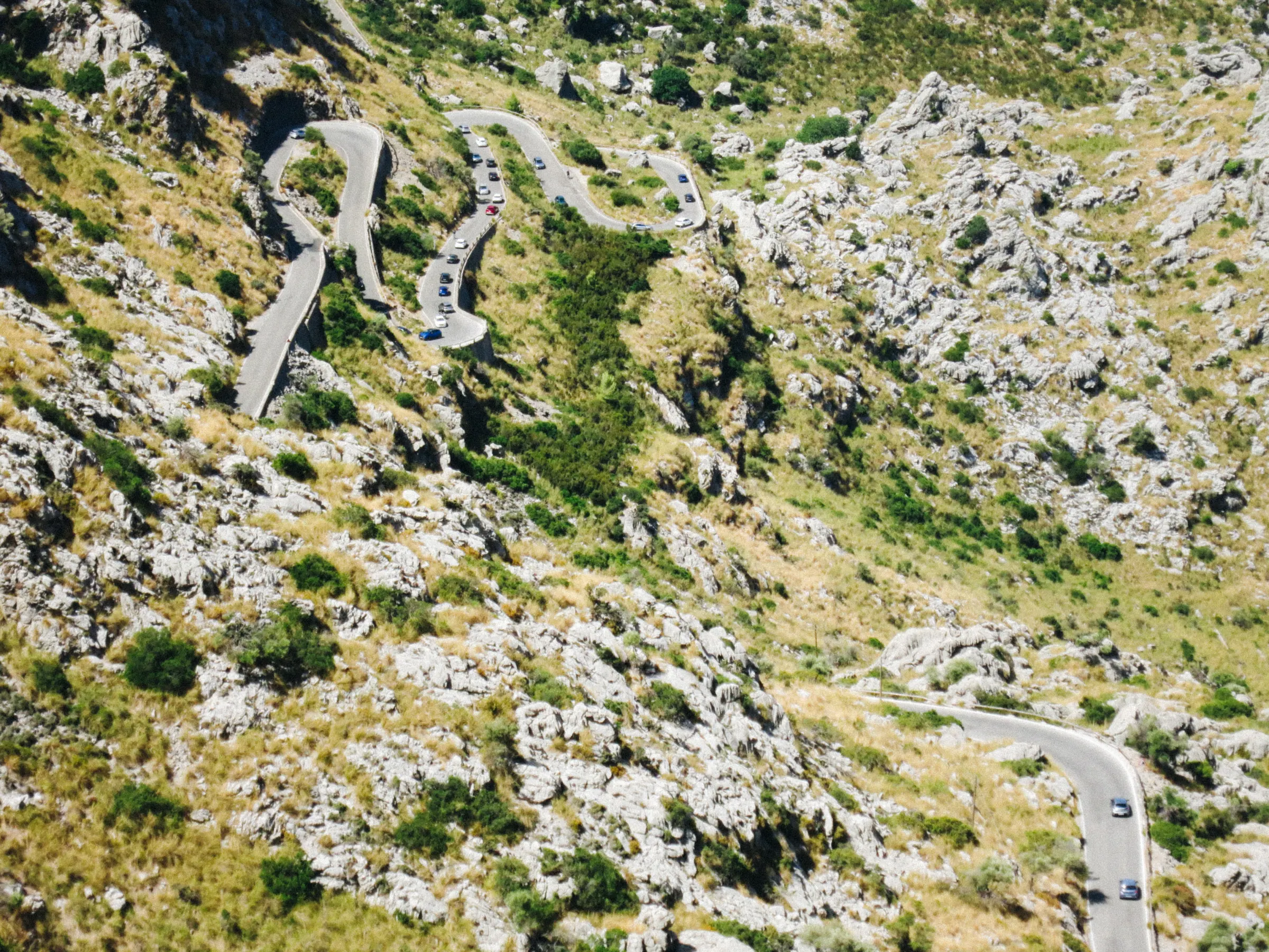 An aerial view of the Sa Calobra road's tight spiral switchback cut into the mountainside